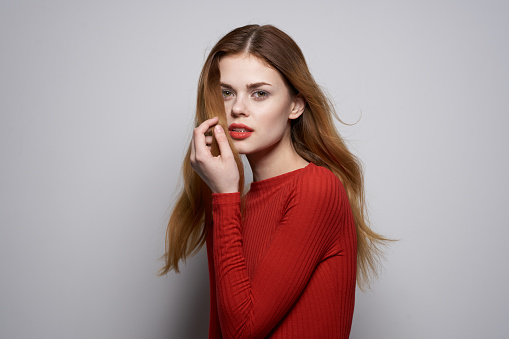 beautiful woman fashion hairstyle red sweater model studio. High quality photo