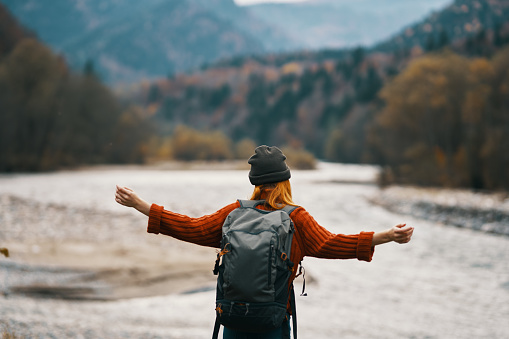 happy woman in warm clothes are resting in the mountains in autumn landscape yellow leaves. High quality photo