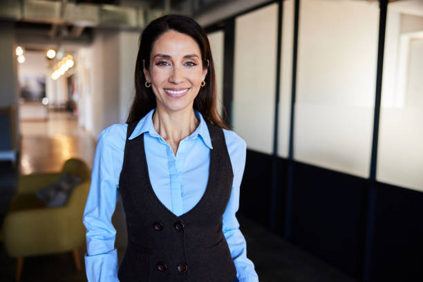 istock Mature businesswoman smiling while standing in a modern office 2120015576