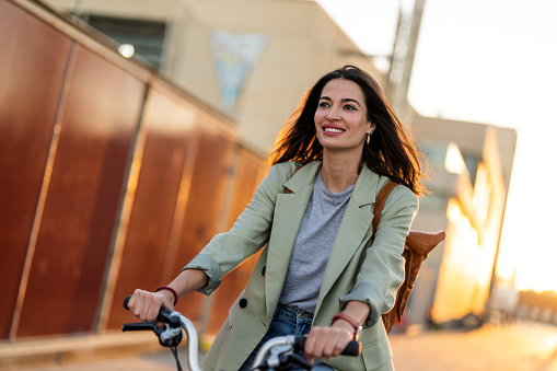 Businesswoman going to work on an electric bicycle