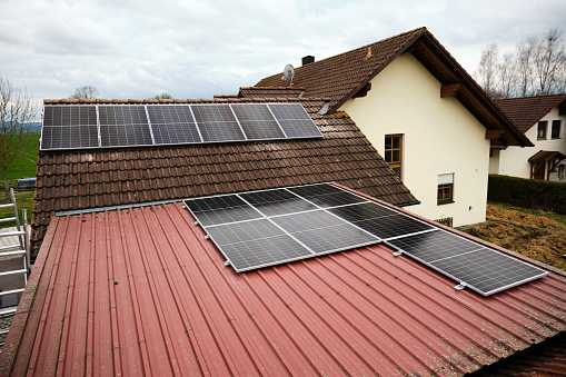 Solar panels are laid on the tin roof of a private house