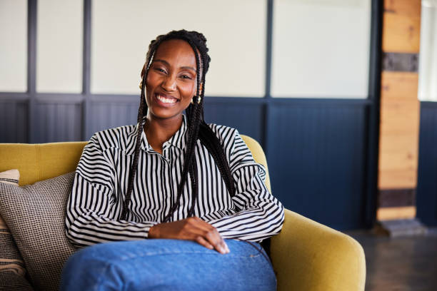 istock Laughing young businesswoman sitting on an office sofa 2120024800