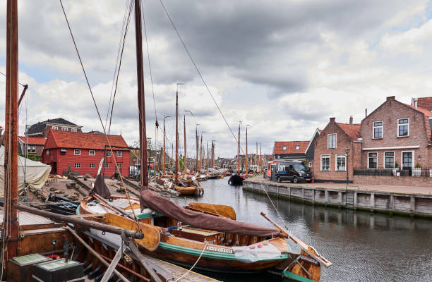 A canal with fishing boats and a shipyard in the background. stock photo