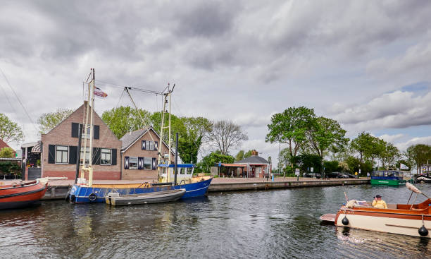 A canal with private boats and houses in the background. stock photo