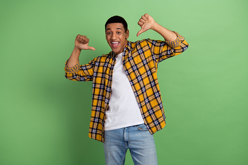 Portrait of excited positive person point thumb fingers self himself isolated on green color background.