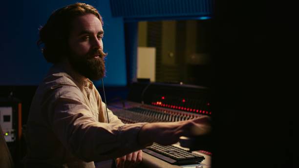 istock Audio expert operating motorized faders and mixing console in control room 2120055185