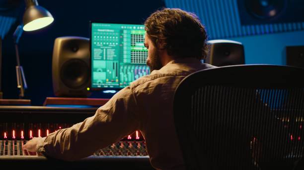 istock Sound designer mixing and mastering tracks on audio console in control room 2120067538