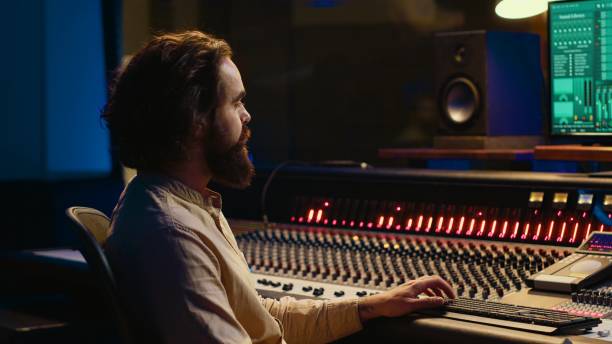 istock Sound designer processing and mixing tunes in control room 2120070152