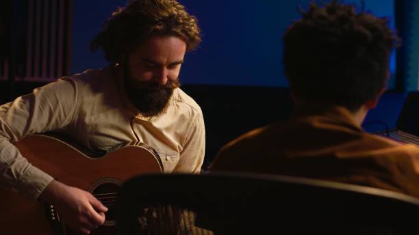 istock Talented artist doing live performance with his guitar in professional studio 2120071701