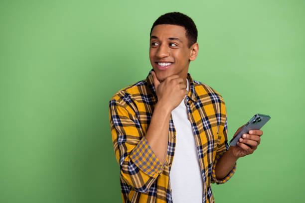 istock Photo of young smart smiling guy manager bloggers using smartphone looking empty space for promo ideas isolated on green color background 2120086682