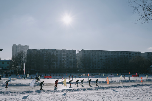 JILIN, CHINA - DECEMBER 26: A group of tourists skating on frozen lake in Public Park during winter day time December 26, 2023 in Jilin, China