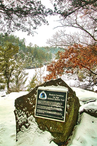 A stone monument near St. Croix Falls, Wisconsin, marks the Western Terminus of the State’s 1200-mile Ice Age Trail, seen here on a snowy winter day overlooking the St. Croix River.