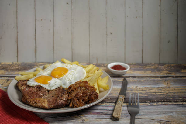 istock Bistec a lo pobre. on Wooden Table 2120168340