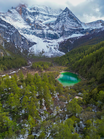 Beautiful scene of mountain and lake at SiChuan, China.drone aerial view of Yading nature reserve in china. snowy Chenrezig picturesquely surrounded by evergreen trees and lake