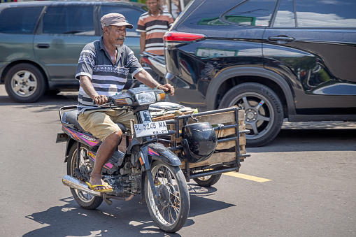 Sabang, Pulau Weh, Indonesia - January 14th 2024:  Man on a motorcycle with a sidecar used for transport of goods