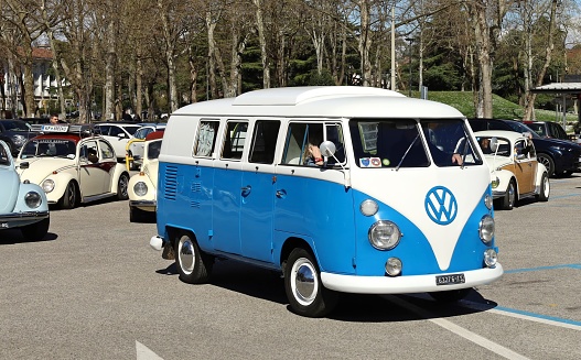 Udine, Italy. March 24, 2024  Vintage VW Transporter Type 2 with some Beetle cars on behind during a Volkswagen classic car parade.