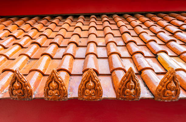Terracotta tiled roof with carved buddha design on pagoda