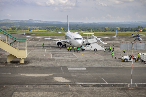 Sultan Iskandar Muda Int'l Airport, Banda Aceh, Sumatra, Indonesia - January 15th 2024:  Airport staff around a Boeing 737 passenger plane