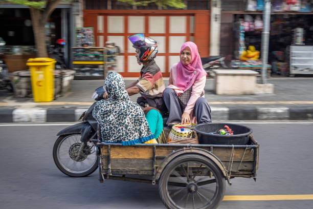 Sabang, Pulau Weh, Indonesia - January 14th 2024:  One man and two women on a motorcycle with a sidecar