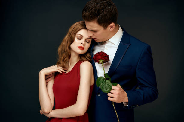 istock luxury couple hug romance relationship rose over dark isolated background 2120205103
