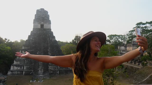 Woman takes a selfie with a pyramid in Central America