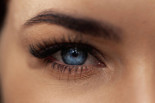 Eyes with arrow makeup in cyan and black. Mature woman, natural.