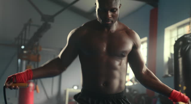 Black man, gym and rope with fitness, wellness and cardio with endurance and progress with training. Person, athlete and guy with practice and jumping with sports and workout with energy and exercise