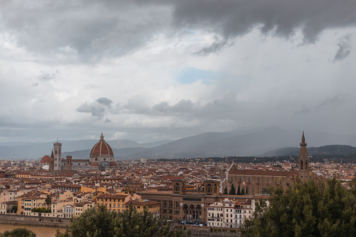 Beautiful historic vintage city with ancient buildings and cathedrals near a mountain on a cloudy rainy day with cloudy skies in Florence, Italy