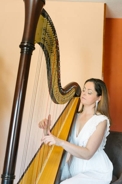 istock Middle aged harpist playing a traditional harp 2120308923