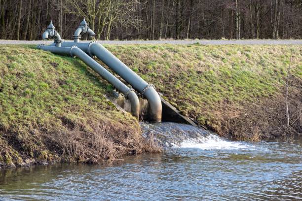 istock pumping station on a river with dike 2120328961