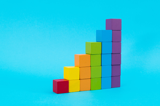 Wooden toy blocks stairs on blue background.