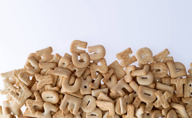 Heap of letter biscuits on white background.