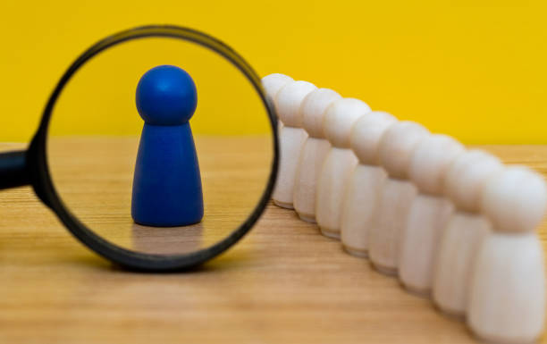 istock Magnifying glass looking at wooden figurine 2120340053