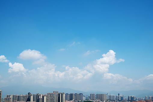 Landscape of city under blue sky and white clouds.