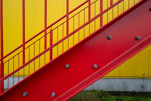 red escape staircase outside staircase on yellow wall industrial building