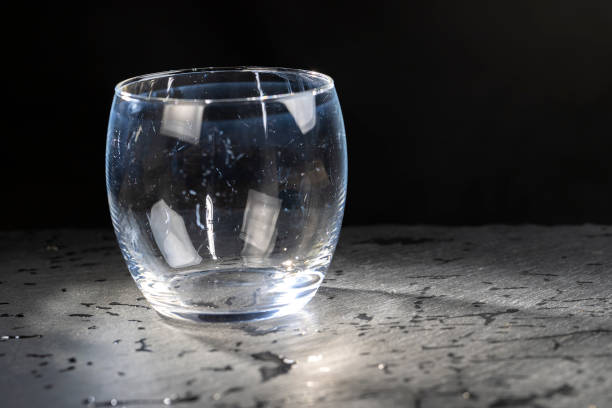 dirty transparent glass on a black slate board, close-up of a transparent glass on a black background