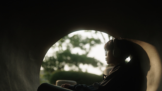 Young asian man calmly relaxing in tunnel of a nature.