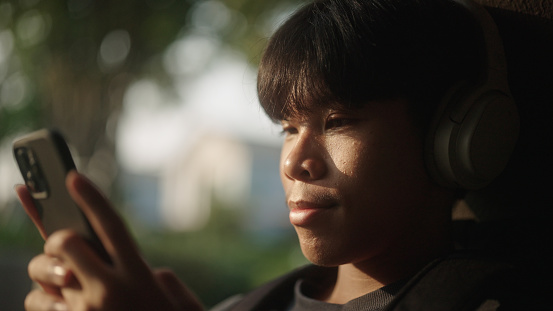 Young asian man wearing a headphone in silhouette.