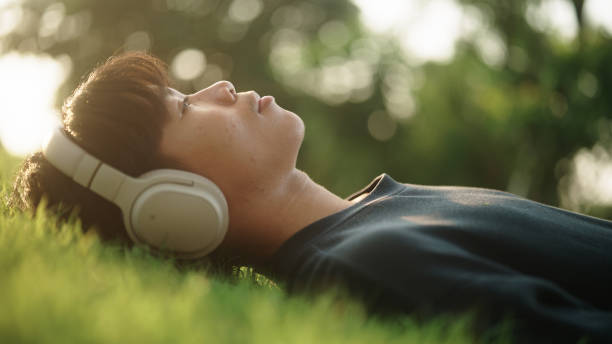 asian teenager relax napping on the grass. - peace on earth audio zdjęcia i obrazy z banku zdjęć