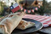 Chilean Pino Empanadas, Round Plate and Wooden Table in Park, Up Close