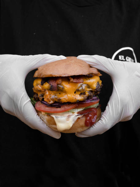 istock Closeup view of a chef wearing white gloves holding a mega burger 2120459979