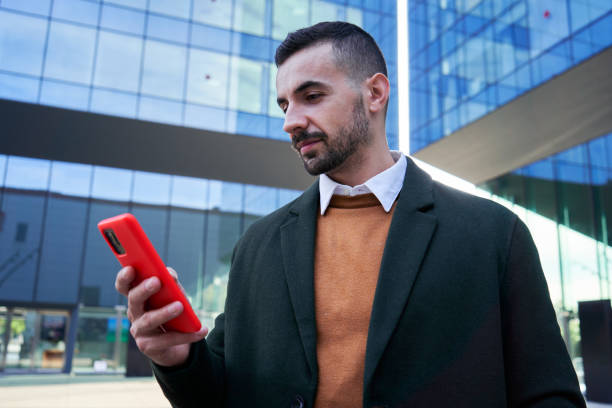 istock Young caucasian real estate agent using mobile phone to send online messages for work. 2120477992