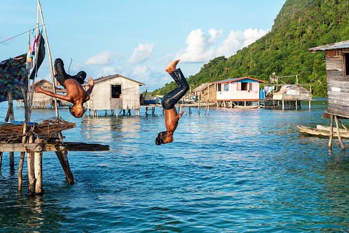 Semporna, Malaysia - November 20, 2021: Kids of Bajau Laut playing in the water