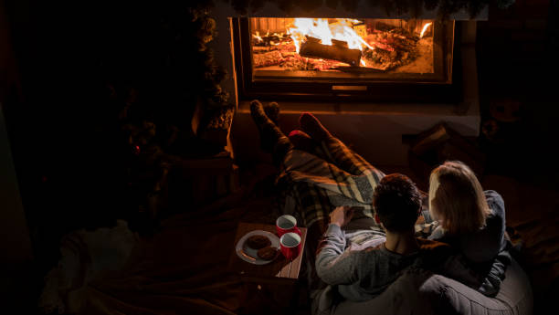 istock Young couple admires the fire in the fireplace, top view 2120491540
