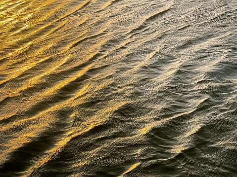 View of sunlight reflecting on a rippled water surface