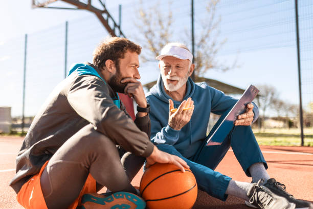 Father and Son Taking Break from Basketball Action Discussing Strategies