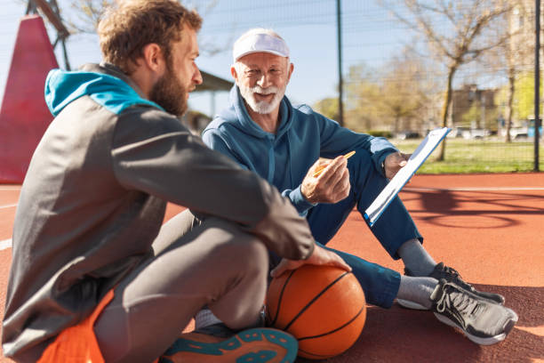 istock Father and Son Catching Breath During Basketball Game 2120509905