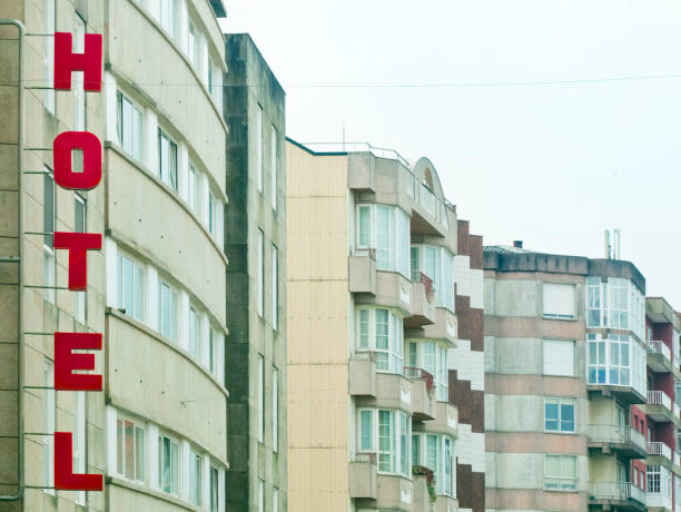Hotel red sign and apartment buildings white facades in a row . Copy space available on the right.  Galicia, Spain.