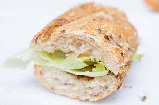 Bread slices with green lettuce inside over white background