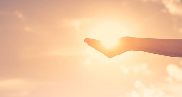 istock Woman holding sun in her hand. 2120557472